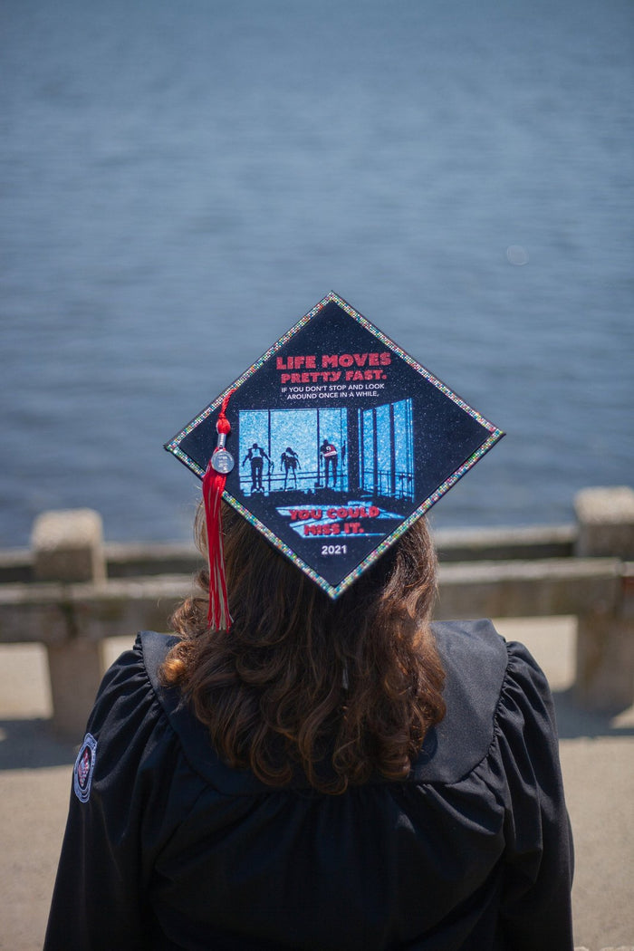 Graduate wearing Ferris Bueller Life Moves Pretty Fast cap