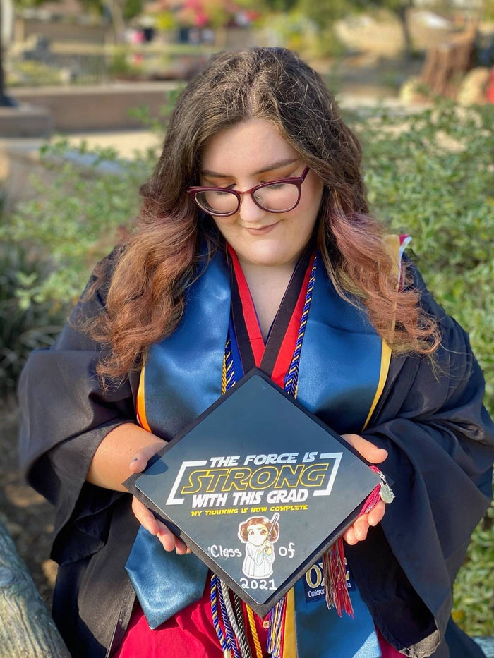 Graduate holding The Force Is Strong bear cap