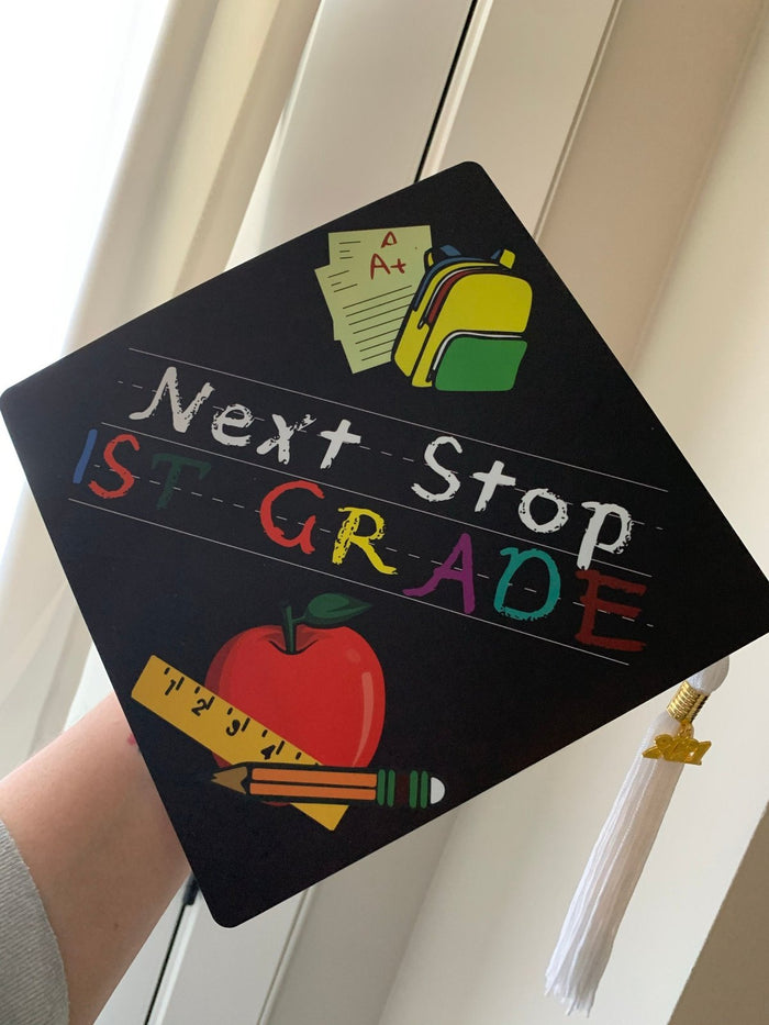 Arm holding Next Stop 1st Grade topper