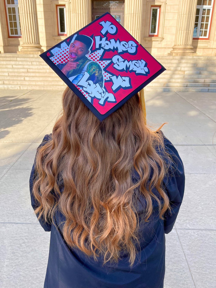 Graduate wearing Fresh Prince Yo Homes cap on campus