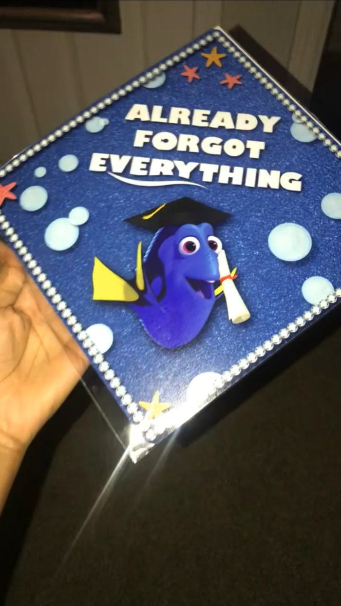Hand holding Dory Already Forgot Everything topper