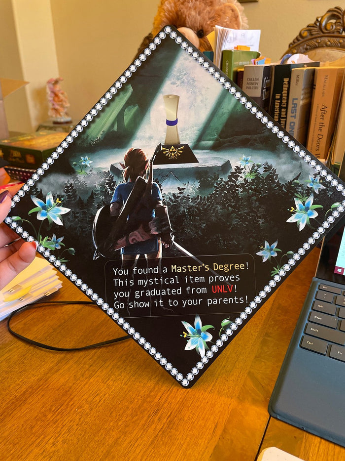 Hand holding Zelda Masters Degree topper