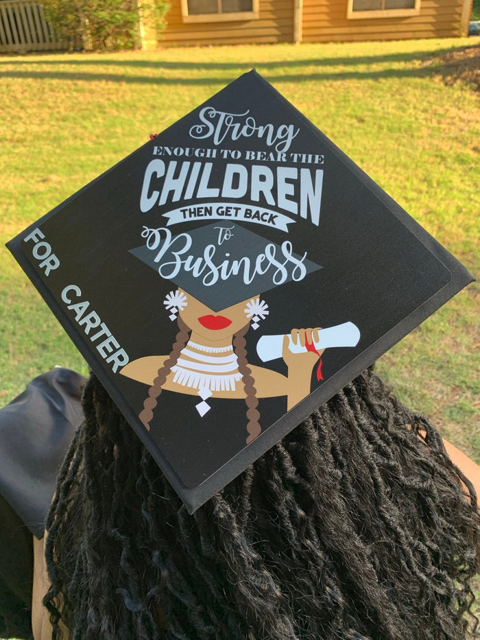 Graduate wearing Strong Enough To Bear The Children topper