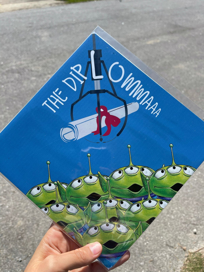 Hand holding blue Toy Story aliens topper