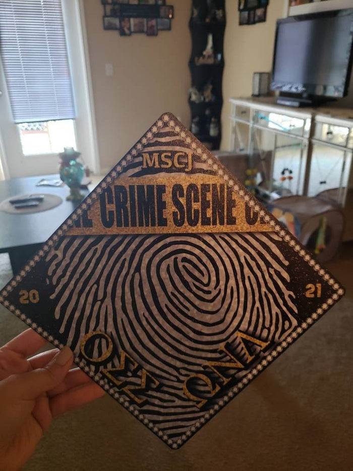 Hand holding crime scene fingerprint topper