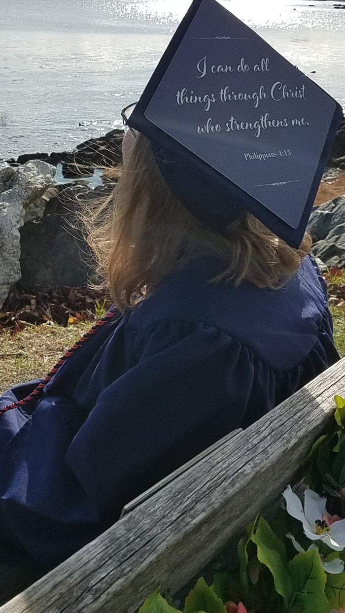Graduate wearing I Can Do All Things cap by the sea