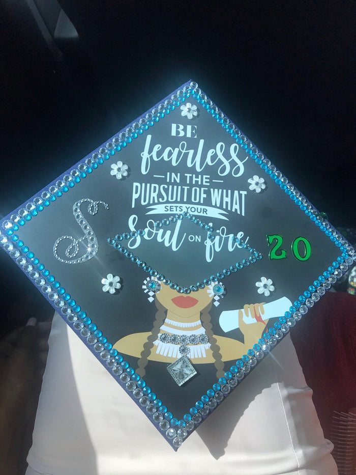 Be Fearless 20 cap on graduates lap in car