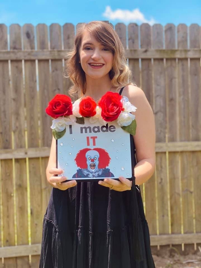 Woman holding Pennywise I Made IT cap with roses