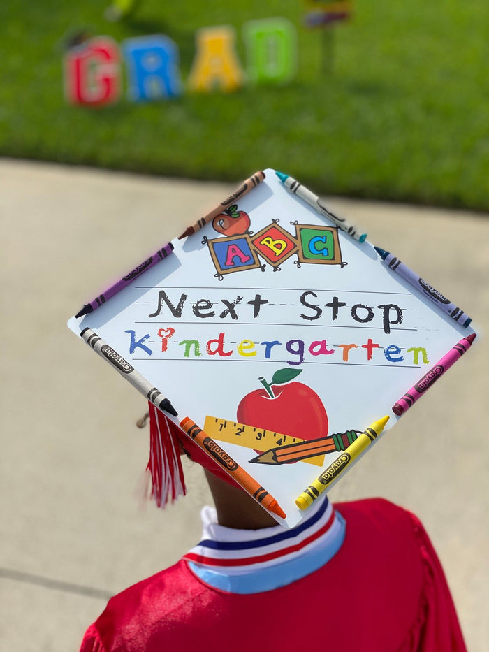 Child wearing Next Stop Kindergarten cap outdoors