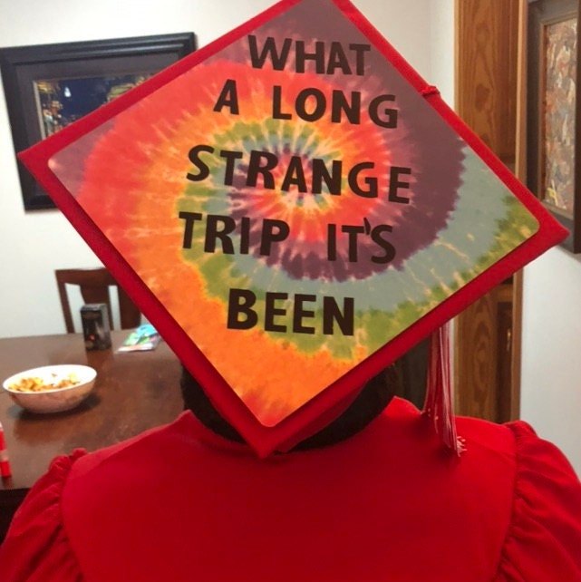 Person wearing tie-dye Long Strange Trip cap