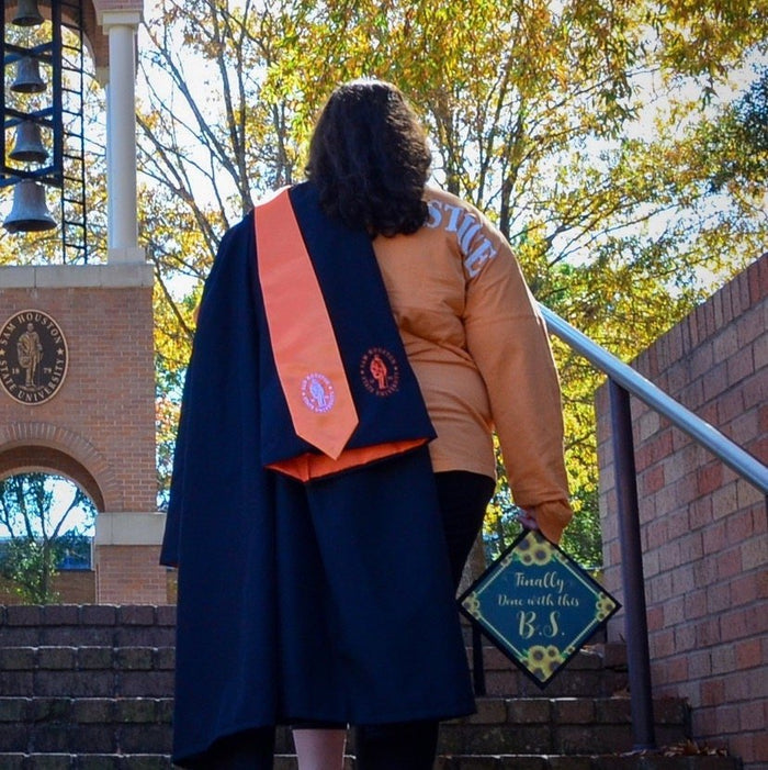 Graduate holding Finally Done With This BS cap on steps