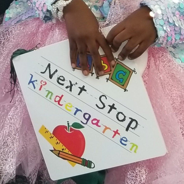 Childs hands placing ABC blocks on Next Stop Kindergarten topper