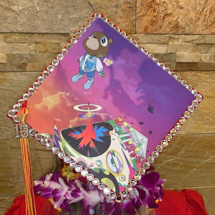 Person wearing rhinestone Kanye cap with lei