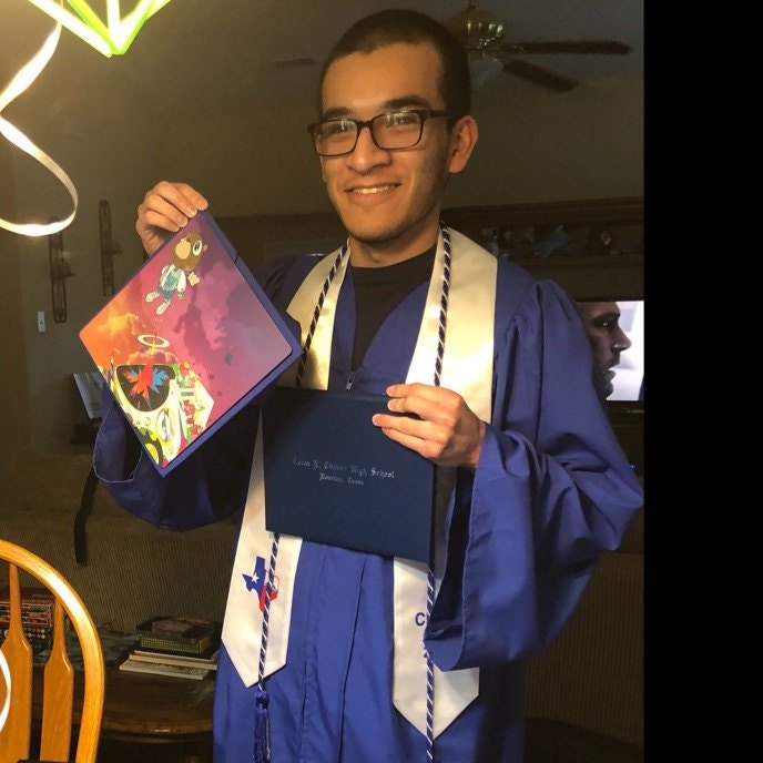 Graduate holding Kanye cap and diploma
