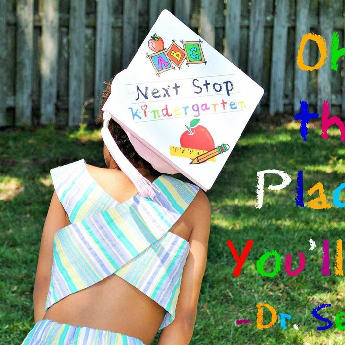 Child wearing Next Stop Kindergarten cap in yard