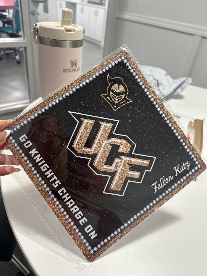 Hand holding UCF Go Knights topper