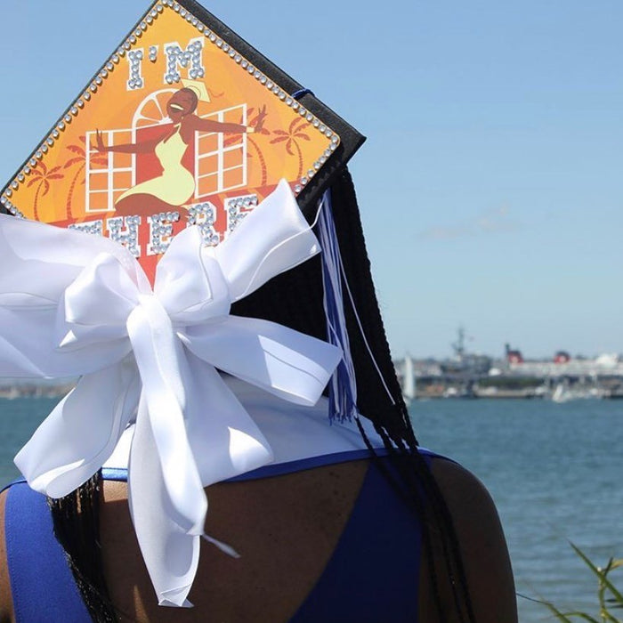 Graduate wearing Im There Tiana cap with white bow
