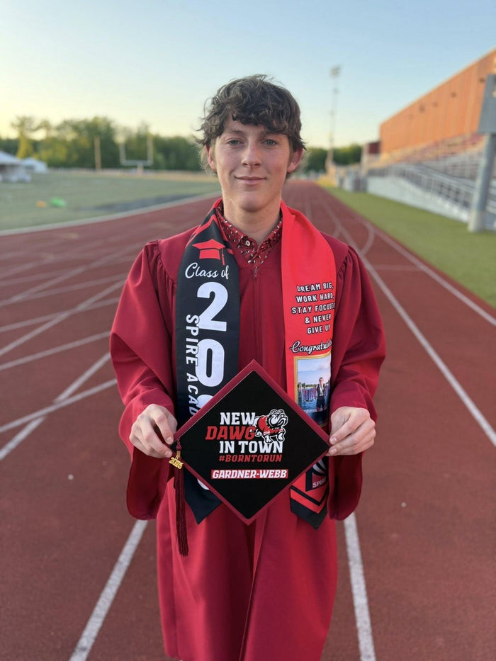 Graduate holding New Dawg In Town cap on track