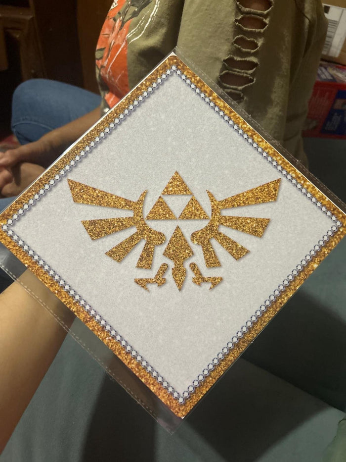 Arm holding Zelda Triforce glitter topper