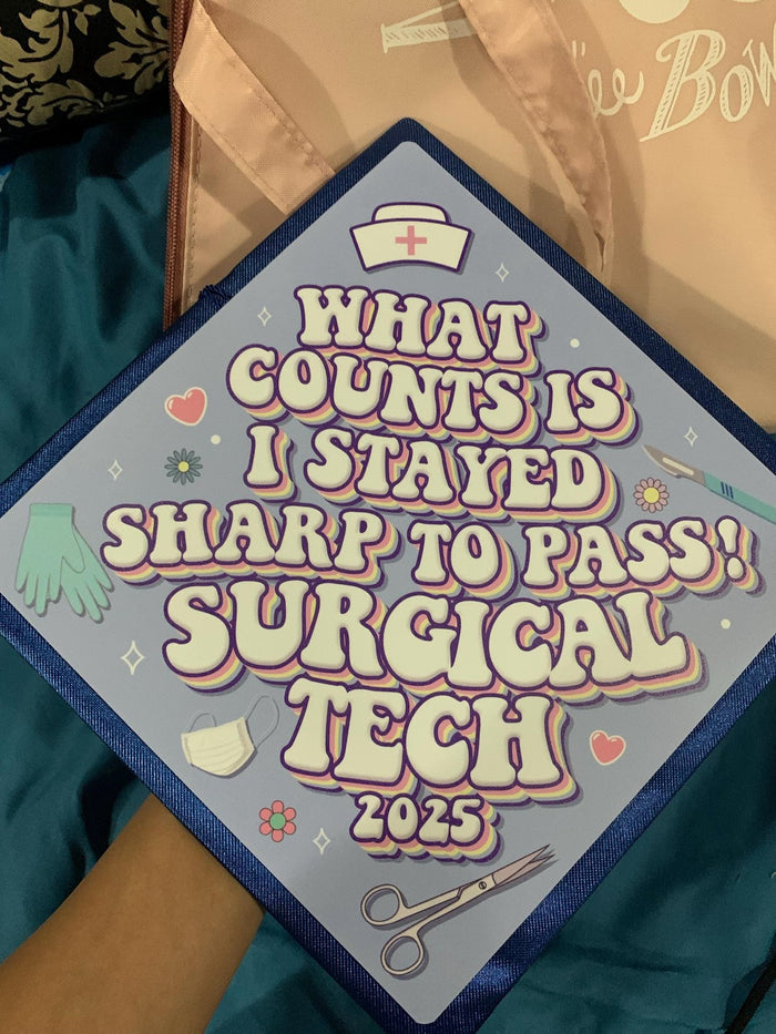 Surgical Tech 2025 cap against graduates arm and lap