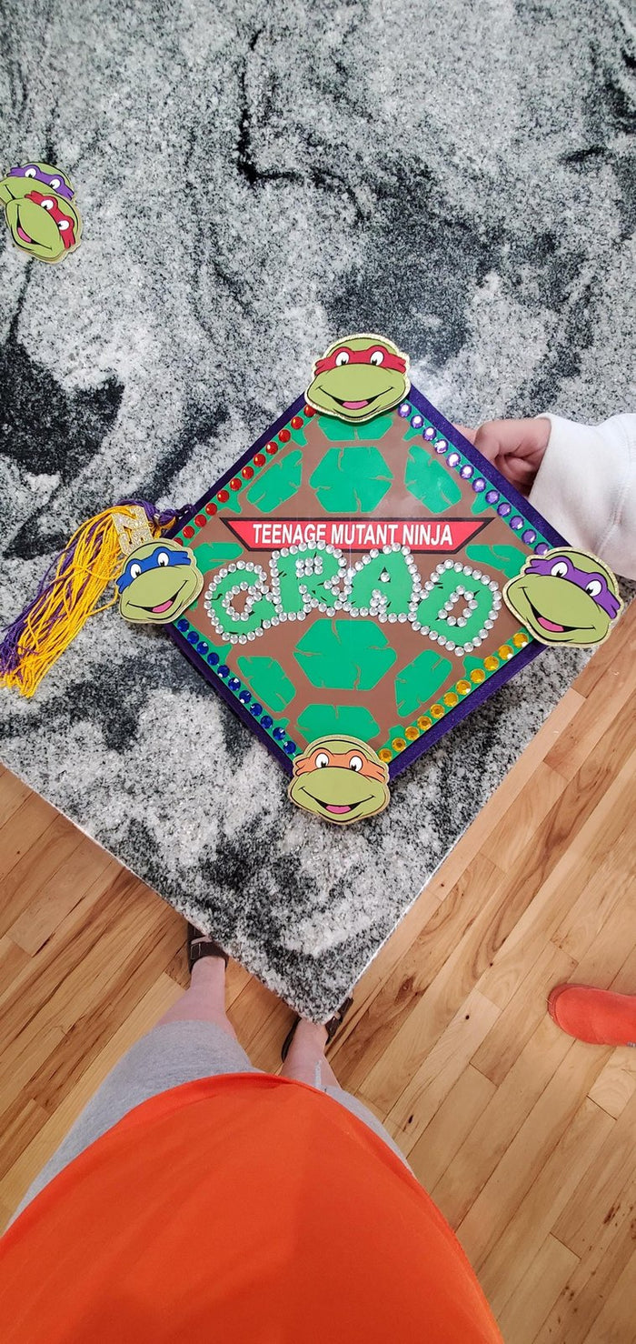 Hand holding TMNT Grad topper