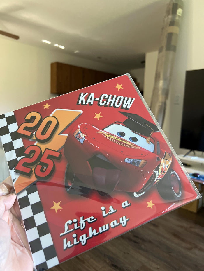 Hand holding Lightning McQueen Ka-Chow 2025 topper