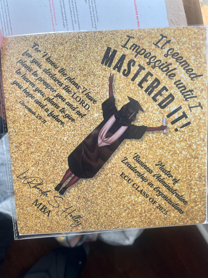 Hand holding ECU MBA Mastered It topper in sleeve