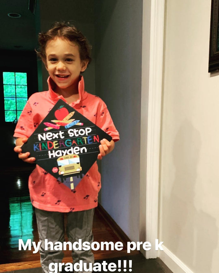 Young boy holding Next Stop Kindergarten Hayden cap