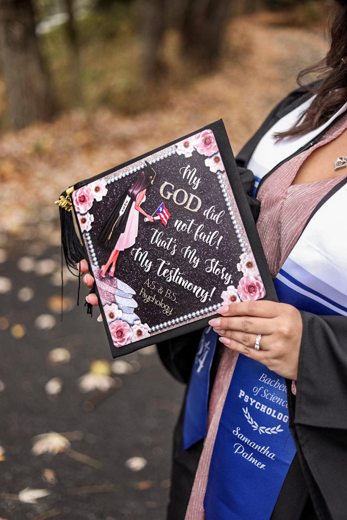 Graduate holding My God Did Not Fail testimony cap