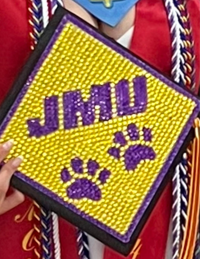Hand holding beaded JMU topper