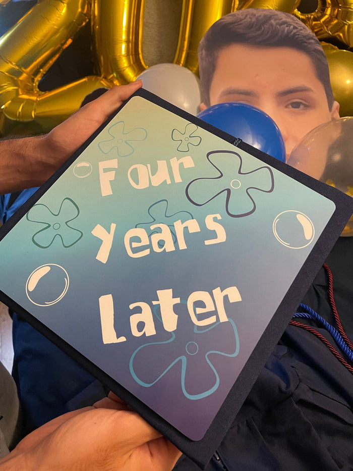 Person holding Four Years Later cap selfie