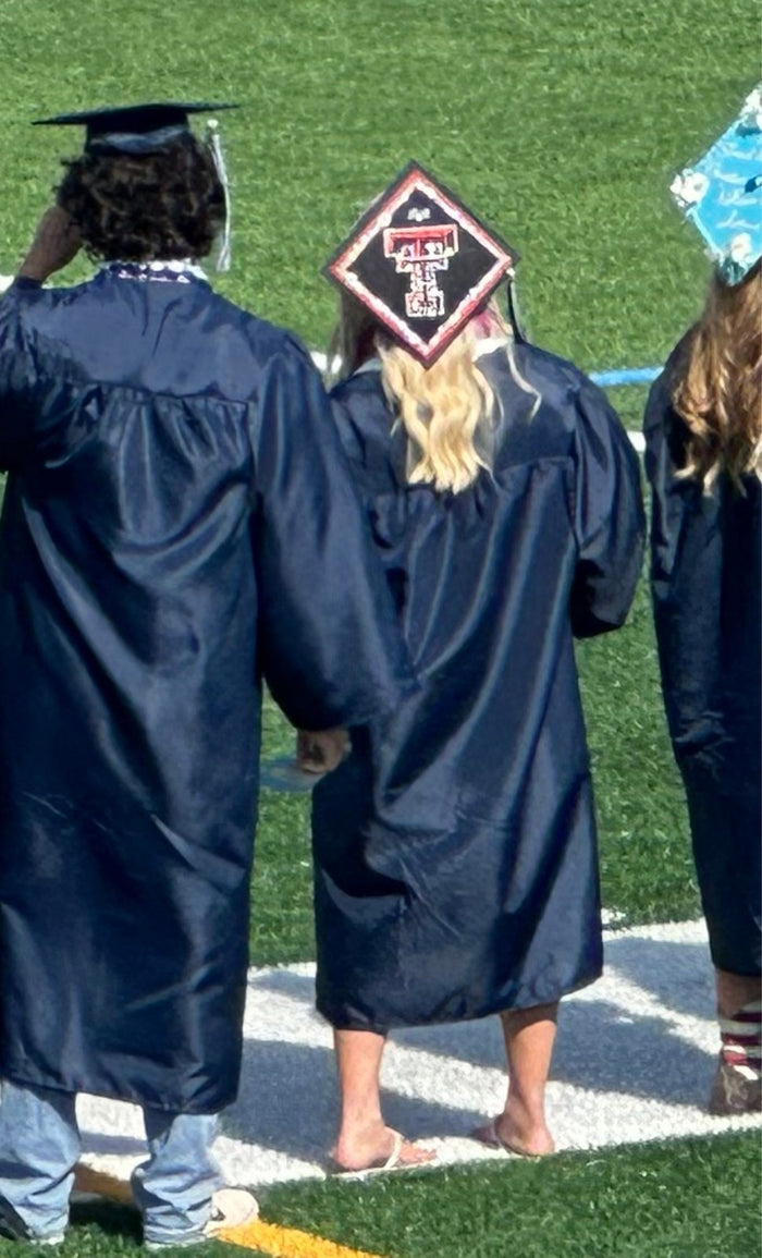 Graduate wearing Texas Tech cap on field