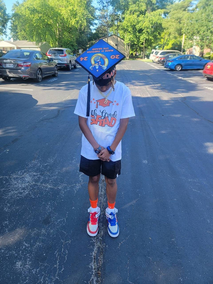 Boy wearing Sonic 5th grade 2024 cap in parking lot
