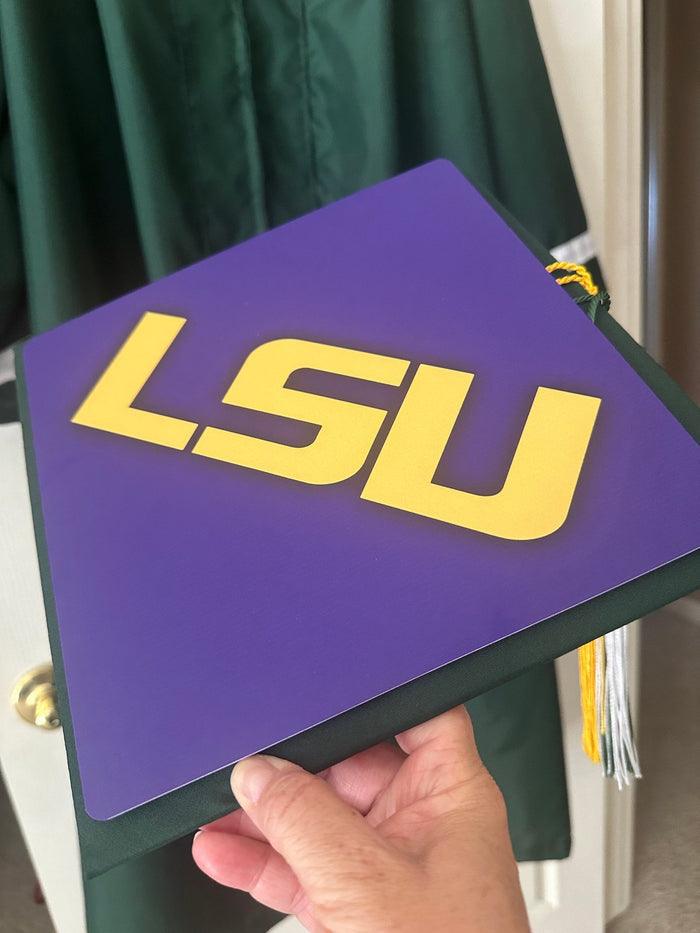 Hand holding LSU purple cap