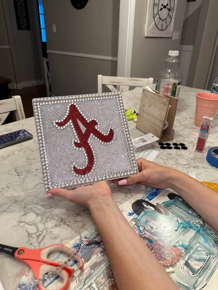 Hands holding Alabama A rhinestone topper