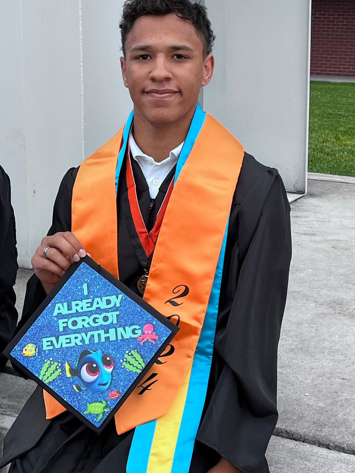 Graduate holding Dory Already Forgot Everything topper