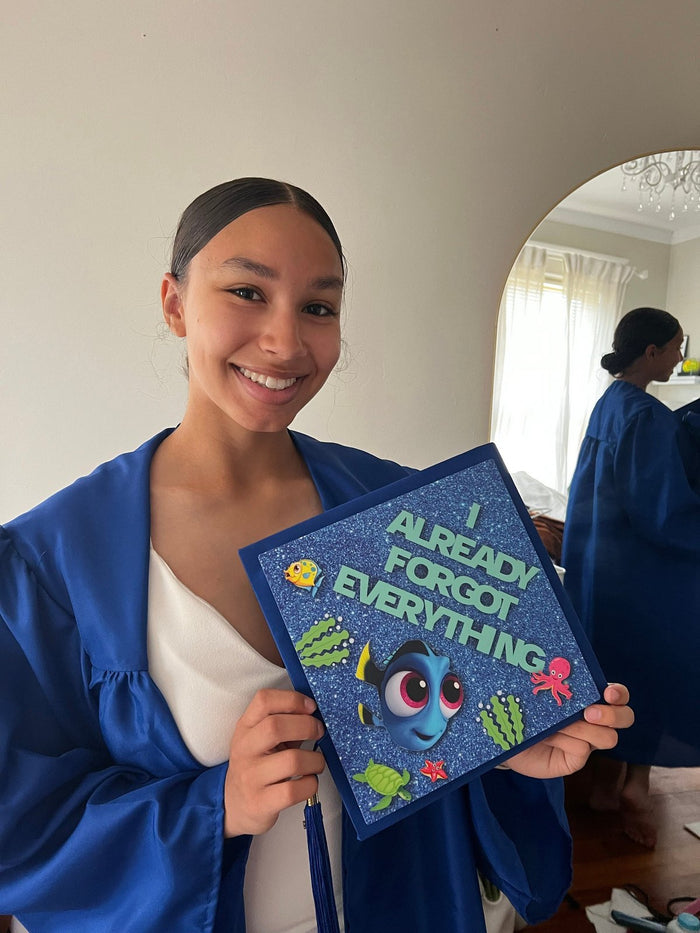 Graduate holding Dory Already Forgot Everything topper