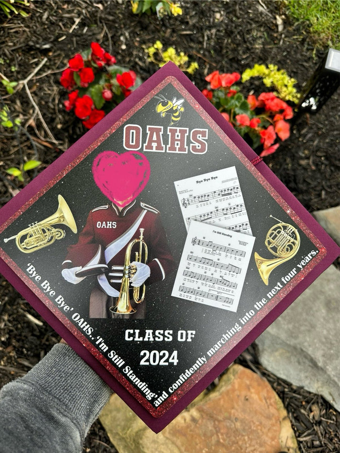 Hand holding OAHS band Class of 2024 topper