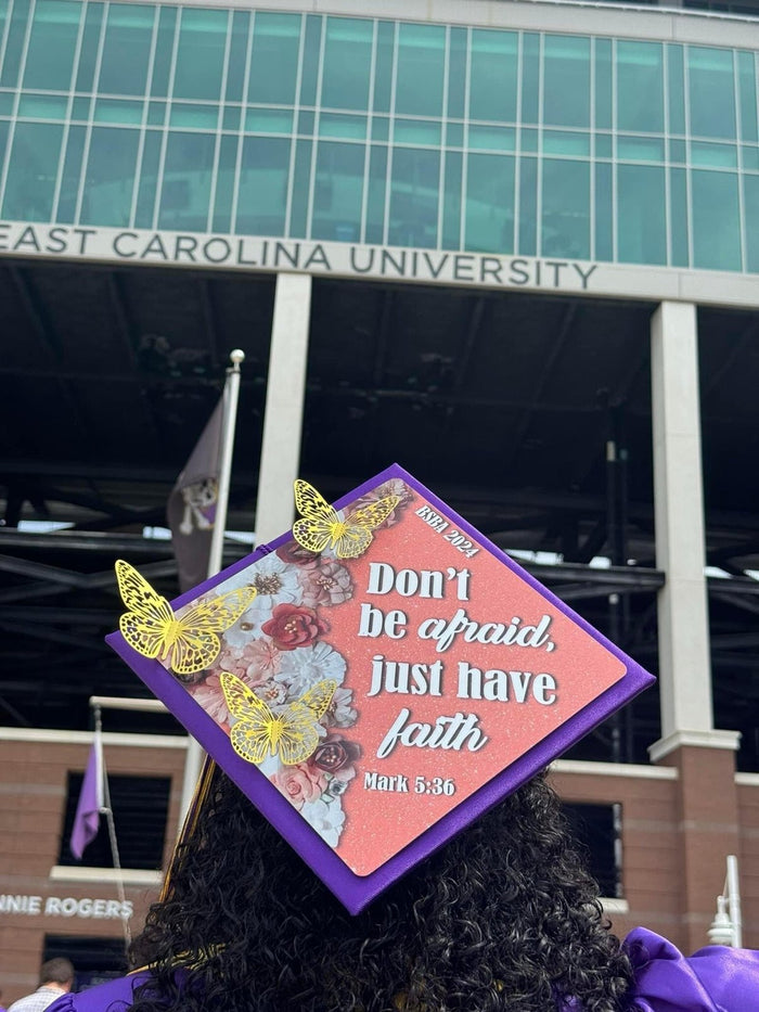 Graduate wearing Dont Be Afraid Just Have Faith cap at ECU