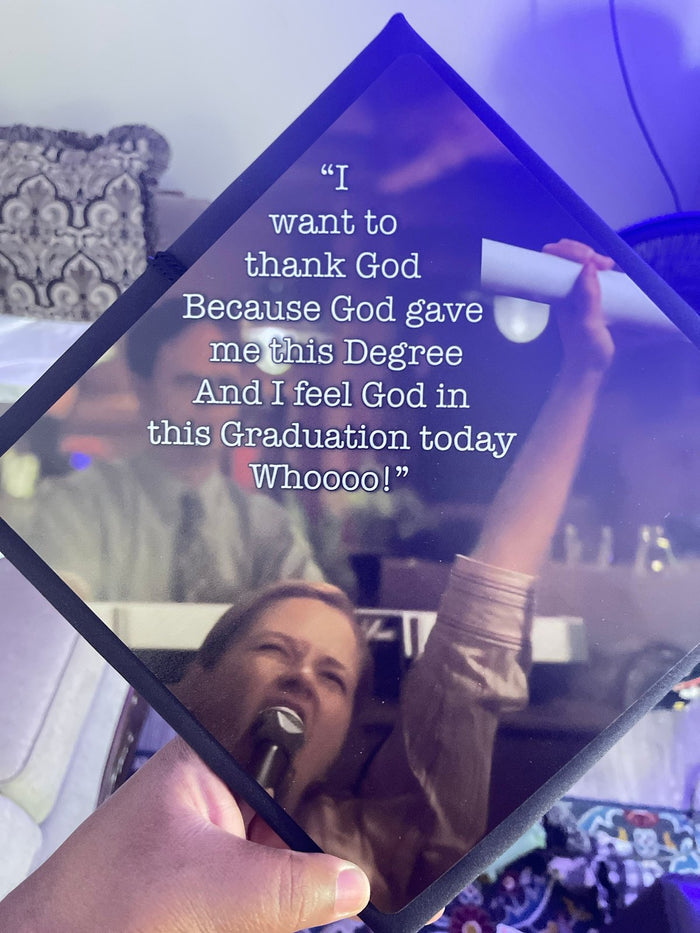 Woman singing with diploma reflected in held acrylic topper