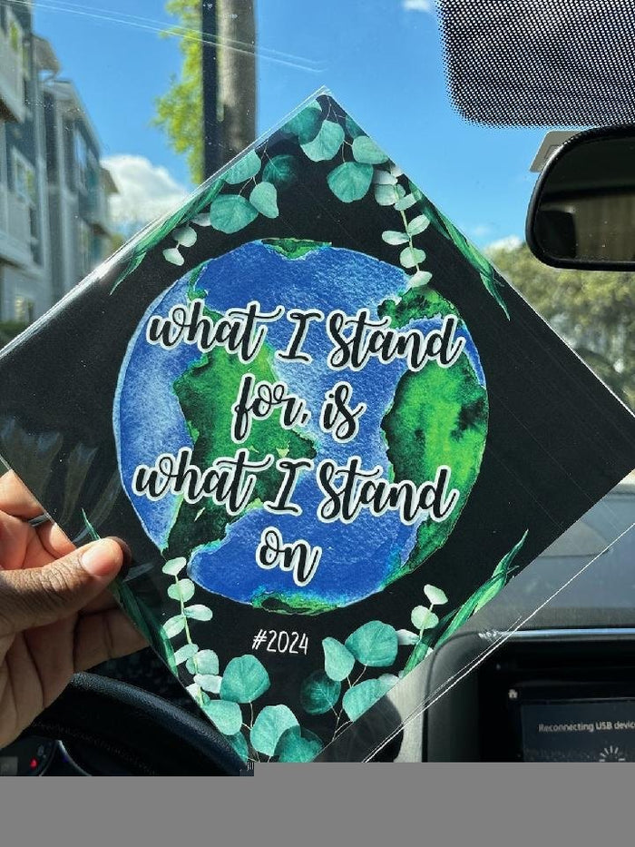 Hand holding What I Stand For earth topper in car