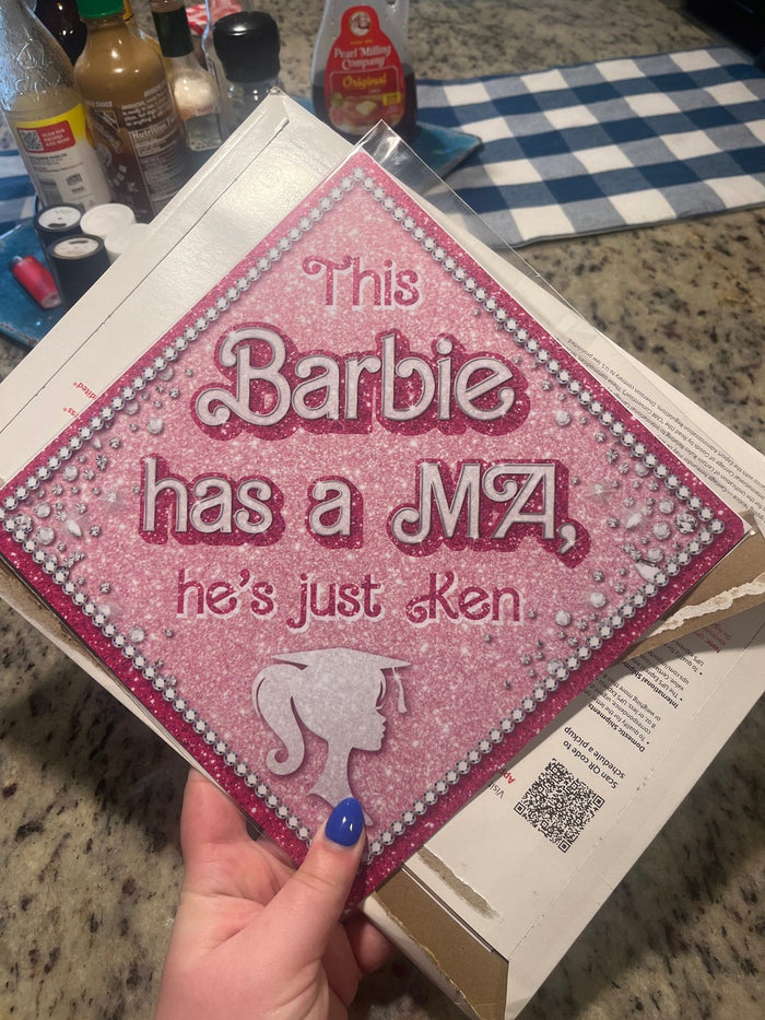 Hand holding This Barbie Has A MA topper