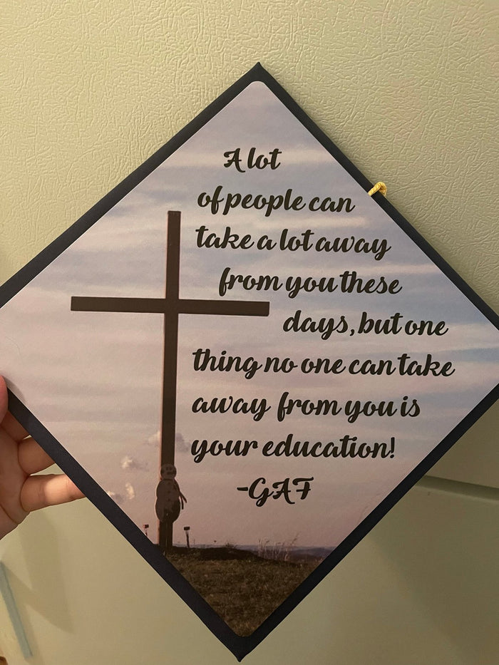 Hand holding cross education quote topper