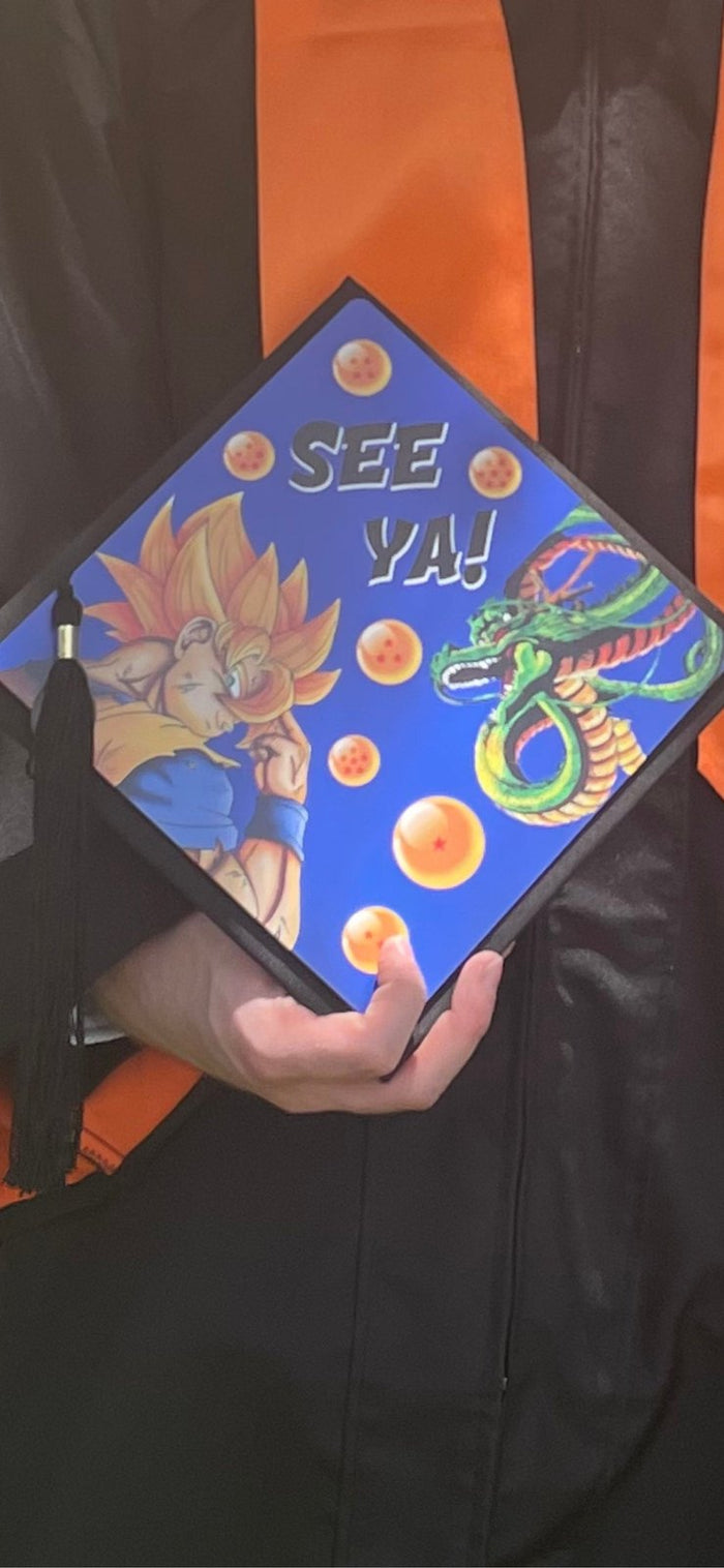 Graduate holding Dragon Ball See Ya cap