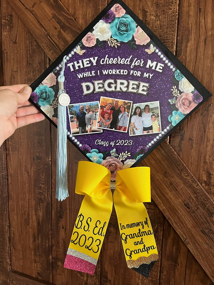 Hand holding They Cheered For Me degree cap