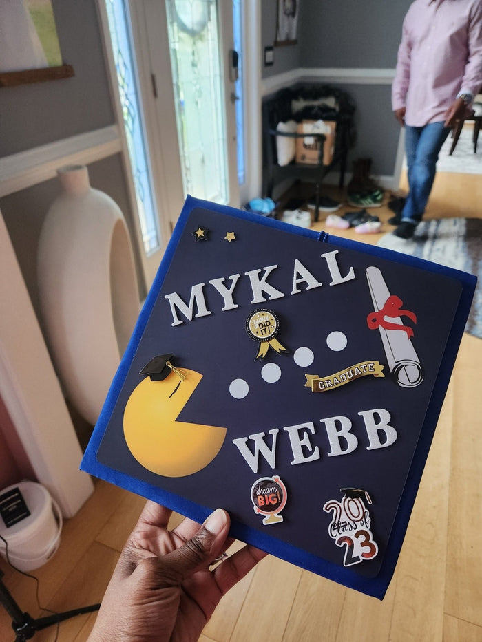 Hand holding Pac-Man Mykal Webb topper
