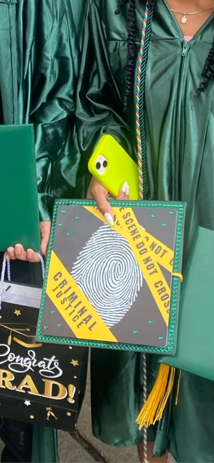 Graduate holding criminal justice fingerprint topper