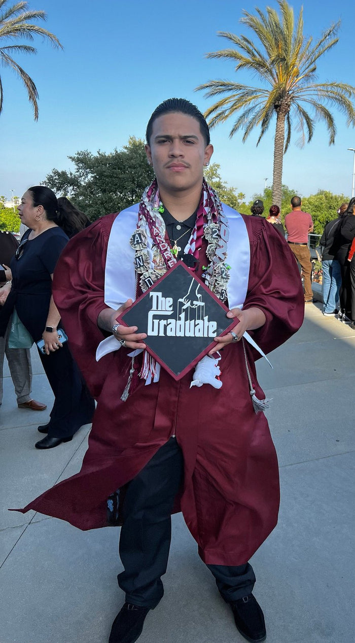 Graduate holding The Graduate Godfather topper
