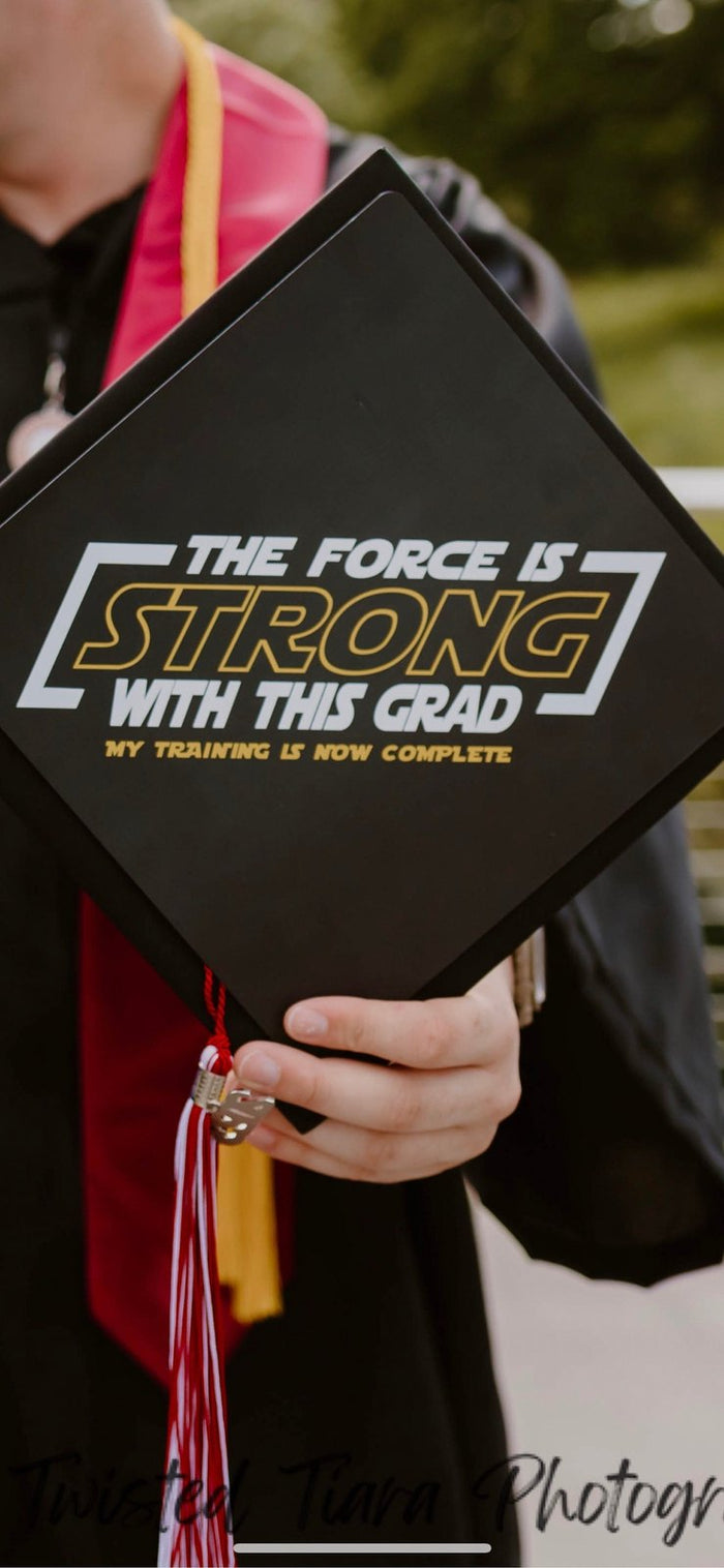 Graduate holding Force Is Strong cap