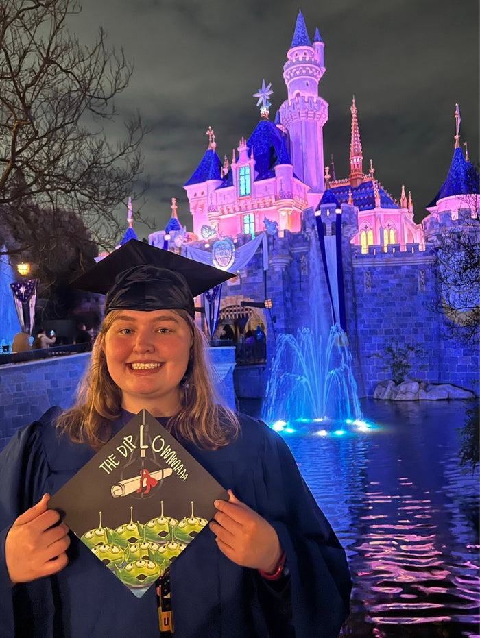 Graduate holding Toy Story The Dip cap at castle